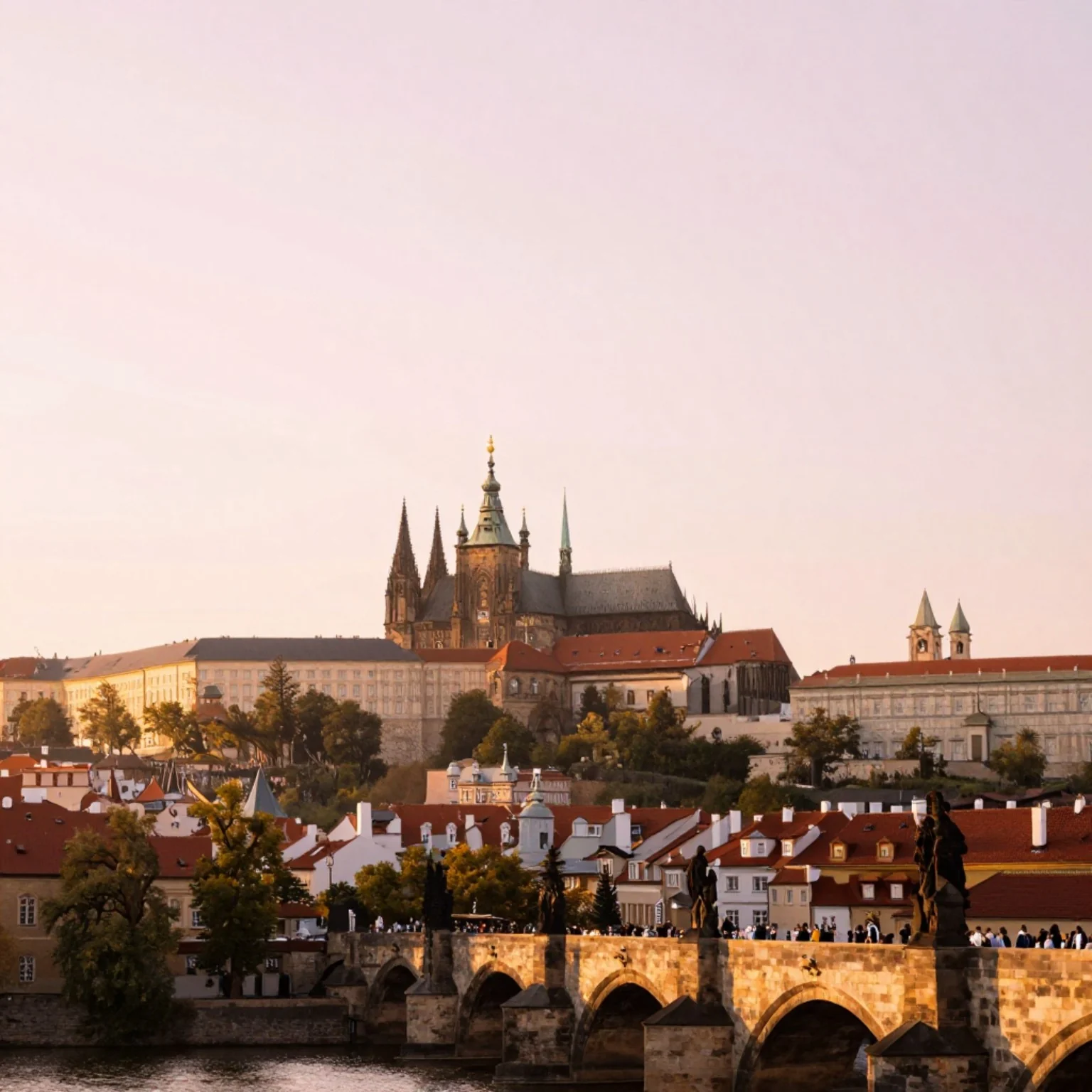 Prague Castle and Charles Bridge at dawn — golden light reflecting on the Vltava river